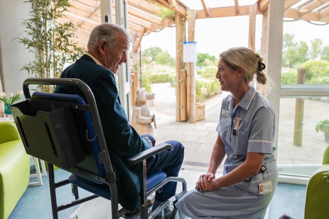Patient sitting down talking with a nurse