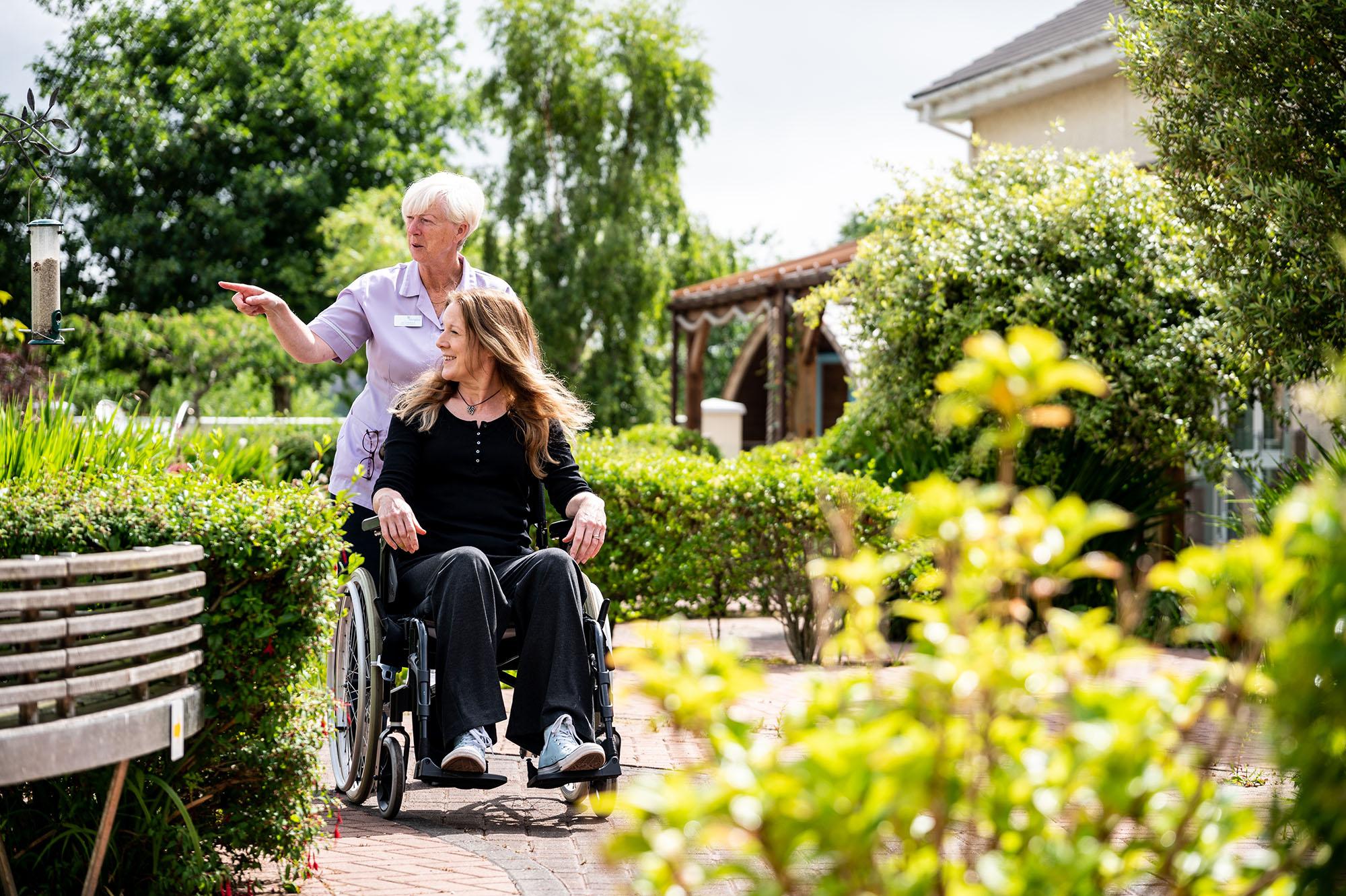 Nurse escorting a patient around the gardens