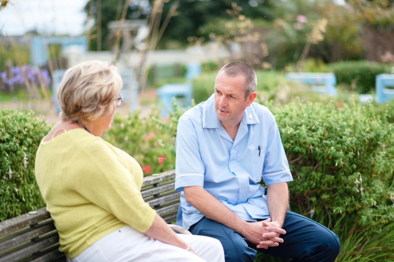 Patient talking to nurse while sitting on a bench