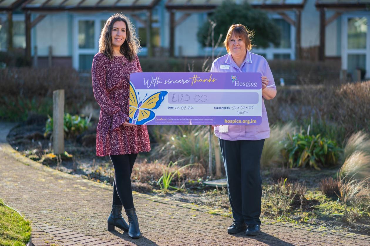 Two ladies holding a cheque for hospice for £125